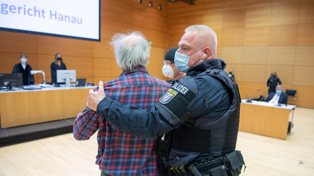 06.10.2021, Hessen, Hanau: Der Angeklagte wird von einem Polizisten in den Verhandlungssaal geführt. Der Mann ist der Vater des Attentäters von Hanau, der 2019 neun Menschen mit Migrationshintergrund aus rechstextremistischen Motiven ermordet hatte,