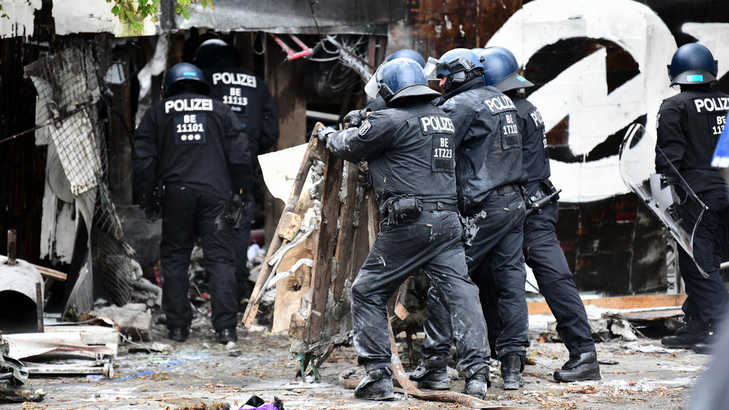 15.10.2021, Berlin: Polizisten räumen Barrikaden am Eingang der Bauwagensiedlung während der Räumung aus dem Weg. Die sogenannte Wagenburg «Köpi» gilt seit vielen Jahren als eines der Symbolprojekte der linksradikalen Szene in Berlin. Foto: Fabian So