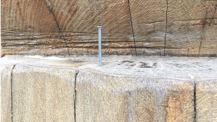 Ein Nagel steckt in einer Sitzgelegenheit aus Holz auf einem Spielplatz in Oldenburg