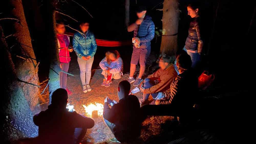 Die Gruppe am Lagerfeuer kurz vor der Explosion. Rechts im Bild Lidiia, ihr Bruder steht links neben ihr am Baum.