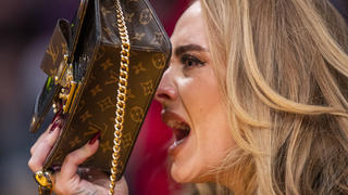 Adele geht bei einem Basketballspiel hinter ihrer Handtasche in Deckung, als ihr Song "Easy On Me" gespielt wird.