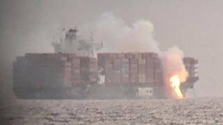 Fire cascades down from the deck of the container ship ZIM Kingston into the waters off the coast of Victoria, British Columbia, Canada, October 23, 2021, as seen through a pair of binoculars, in this image obtained via social media. SURFRIDER FOUNDATION CANADA via REUTERS   ATTENTION EDITORS - THIS IMAGE HAS BEEN SUPPLIED BY A THIRD PARTY. MANDATORY CREDIT. NO RESALES. NO ARCHIVES. THIS PICTURE WAS PROCESSED BY REUTERS TO ENHANCE QUALITY. AN UNPROCESSED VERSION HAS BEEN PROVIDED SEPARATELY