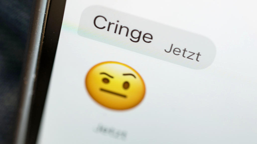 24.10.2021, Baden-Württemberg, Stuttgart: ILLUSTRATION - Das Wort ·cringe· ist auf dem Display eines Mobiltelefons zu sehen. Am 25. Oktober wird das «Jugendwort des Jahres» 2021 bekanntgegeben. In der Endauswahl standen die Worte «sheesh», «sus» und