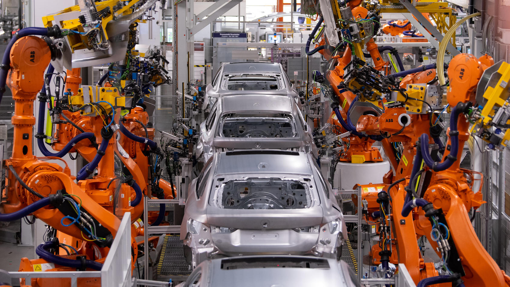 22.10.2021, Bayern, München: Roboter arbeiten an der Karosserie von verschiedenen BMW-Modellen im Stammwerk. Drei Monate nach dem Elektro-SUV BMW iX hat der Autobauer jetzt auch die Serienproduktion des vollelektrischen BMW i4 gestartet. Im Stammwerk