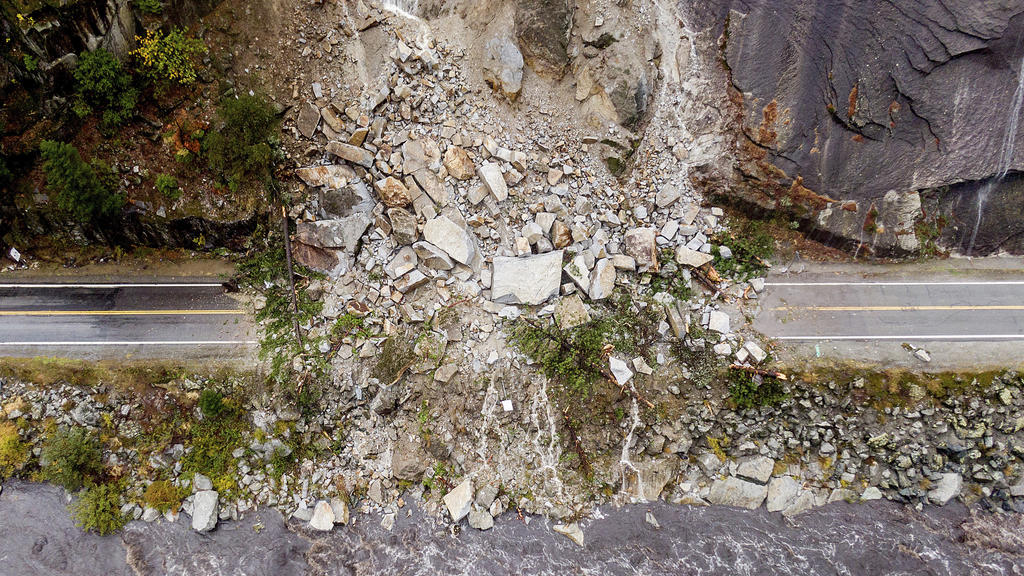 Rocks and vegetation cover Highway 70 following a landslide in the Dixie Fire zone on Sunday, Oct. 24, 2021, in Plumas County, Calif. Heavy rains blanketing Northern California created slide and flood hazards in land scorched during last summer's wil