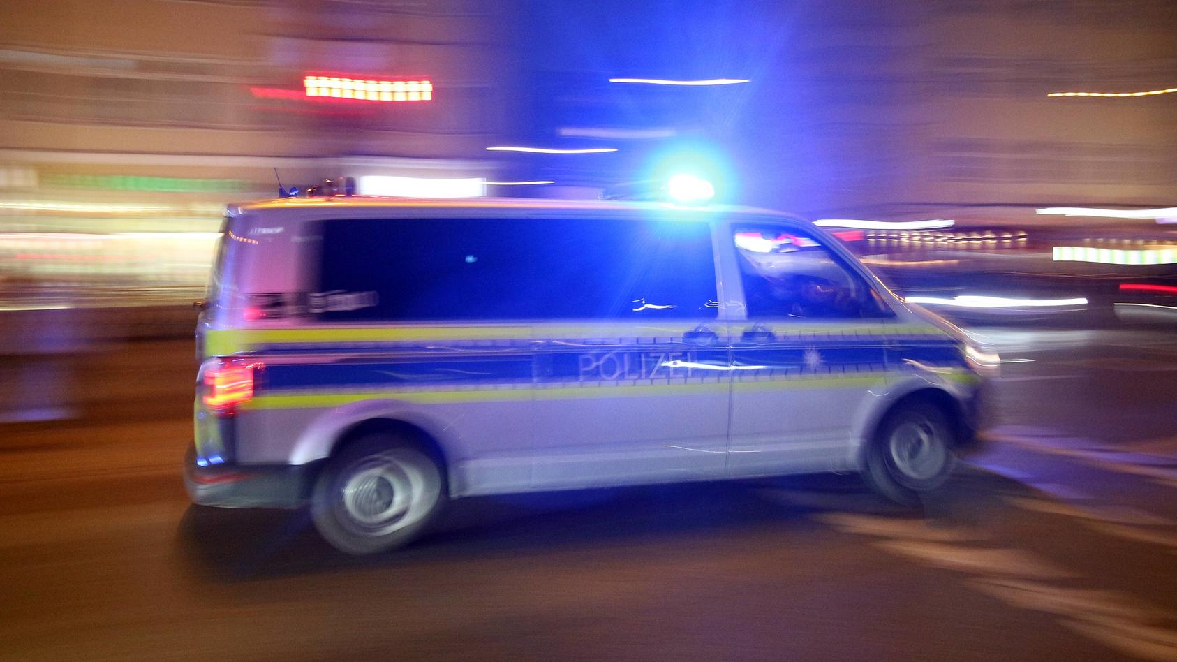 Einsatzwagen der Polizei mit eingeschaltetem Blaulicht bei einem Einsatz in München am Abend, Bayern, Deutschland *** Racing car of the police with the blue light on a mission in Munich on the night of Bavaria Germany  