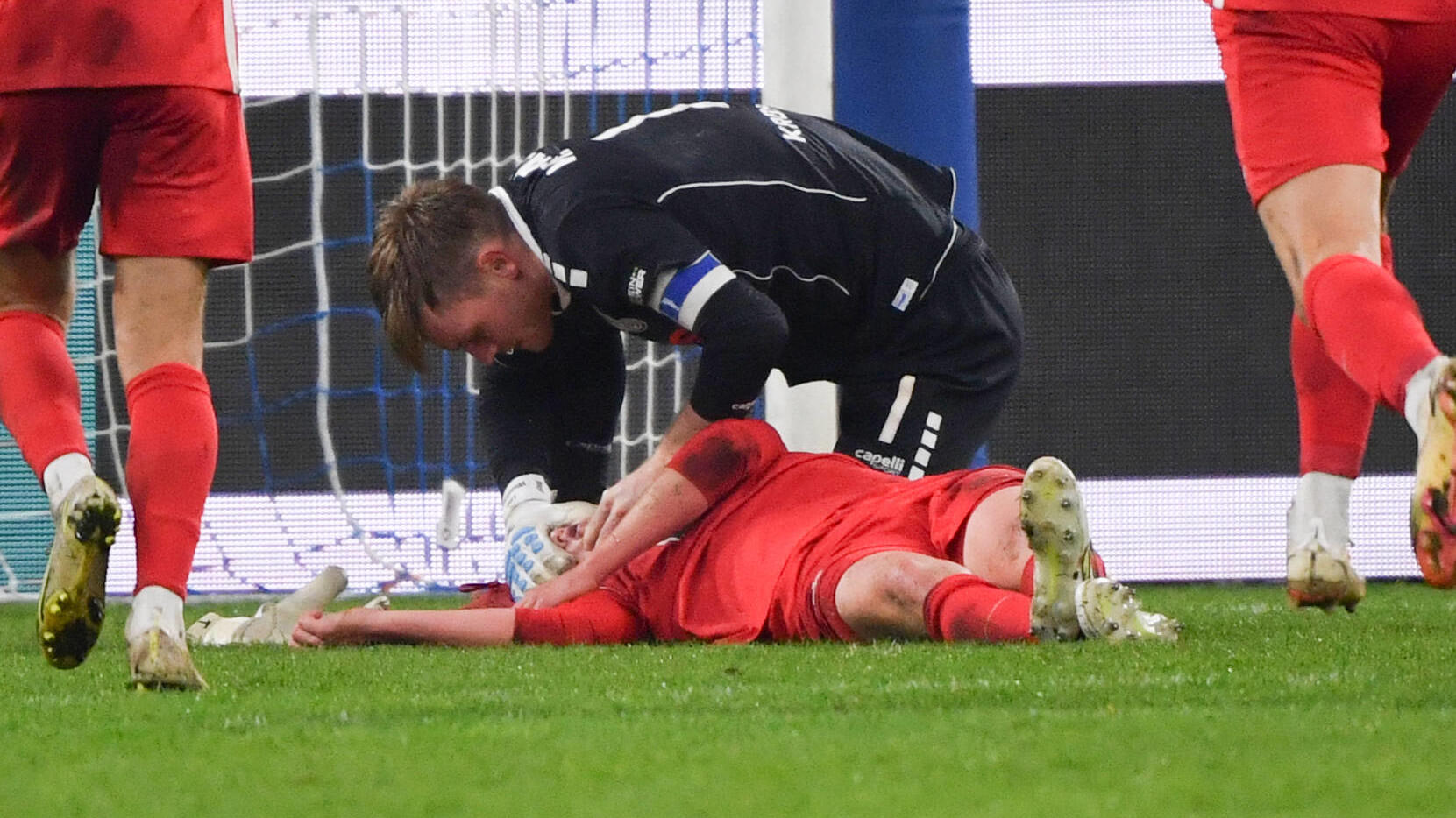Torwart Leo Weinkauf (MSV Duisburg) hilft dem verletzten Felix Götze (1. FC Kaiserslautern).