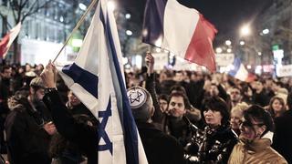 People hold French and Israeli (L) flags as they attend a silent march in Paris March 19, 2012, to pay tribute to the four victims killed by a gunman at a Jewish school in Toulouse on Monday. A gunman shot dead three children and a rabbi at a Jewish school in Toulouse on Monday, days after killing three soldiers nearby, prompting French President Nicolas Sarkozy to put the region on its highest terrorism alert.  REUTERS/Charles Platiau   (FRANCE - Tags: CRIME LAW OBITUARY)