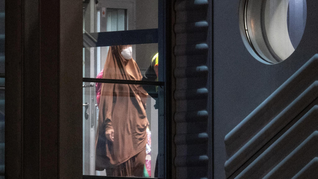 Frankfurt/Main: Eine verschleierte Frau mit einer Maske betritt aus der Gangway einer Chartermaschine heraus einen abgeschirmten Bereich der Bundespolizei am Flughafen Frankfurt.