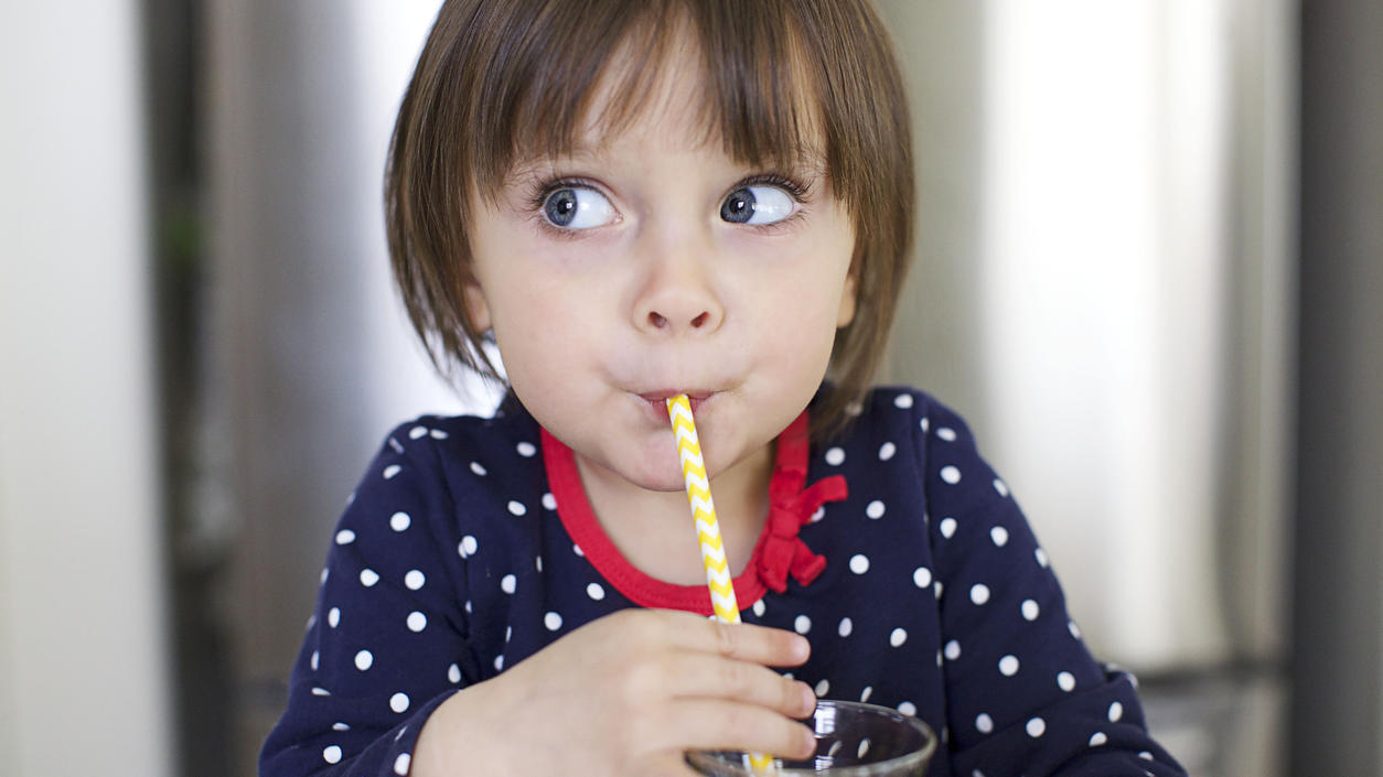 Kind trinkt aus Papier-Trinkhalm