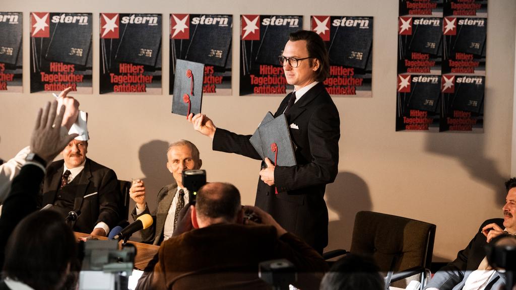 Pressekonferenz in der Stern Redaktion: Gerd Heidemann (Lars Eidinger) präsentiert die Hitler Tagebücher und liest aus ihnen vor.