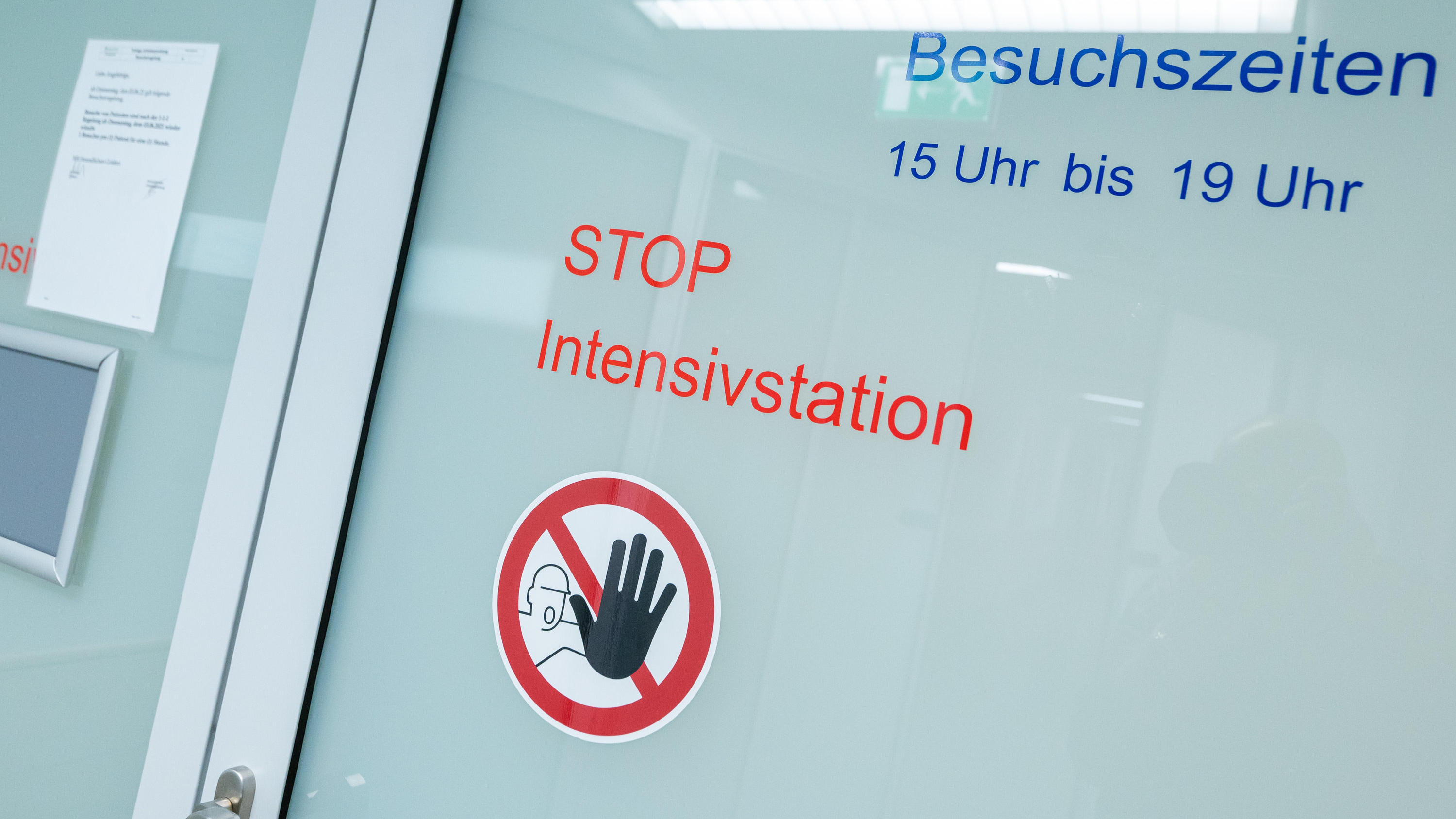Die Aufschrift «STOP Intensivstation» klebt in der Asklepios Klinik an einer automatischen Glastür. Foto: Peter Kneffel/dpa +++ dpa-Bildfunk +++