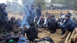  GRODNO REGION, BELARUS - NOVEMBER 10, 2021: Migrants sit by a bonfire at a tent camp on the Belarusian-Polish border. According to the Polish Border Guard, several thousand migrants have been approaching the Polish border since November 8, 2021. Since the start of 2021, over 30 thousand migrants have attempted to cross the Belarusian-Polish border. Poland has declared a state of emergency in the regions bordering Belarus. Leonid Shcheglov/BelTA/TASS PUBLICATIONxINxGERxAUTxONLY TS1175D7
