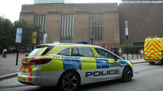04.08.2019, Großbritannien, London: Einsatzwagen stehen vor dem Tate Modern Museum. Ein 17-Jähriger soll einen sechsjährigen Jungen von einer Aussichtsplattform im zehnten Stock geworfen haben. Der Jugendliche wurde wegen des Verdachts auf versuchten Mord festgenommen, wie Scotland Yard mitteilte. Ein Rettungshubschrauber brachte das Kind in ein Krankenhaus. Foto: Yui Mok/PA Wire/dpa +++ dpa-Bildfunk +++