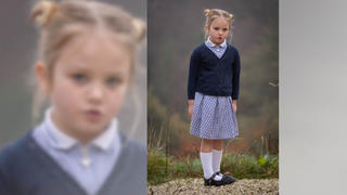 Die zierliche fünfjährige Lily steht in einem blauen Kleid vor der Kamera.