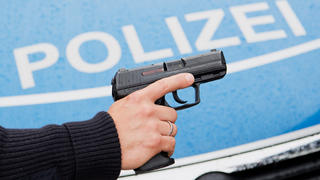 ARCHIV - 13.06.2016, Niedersachsen, Hannover:  Ein Polizist posiert für Fotoaufnahmen mit seiner Dienstwaffe HK P2000 9mm vor einem Polizeifahrzeug. (zu dpa "Polizisten machen nur selten von der Waffe Gebrauch" vom 22.07.2018) Foto: Julian Stratenschulte/dpa +++ dpa-Bildfunk +++