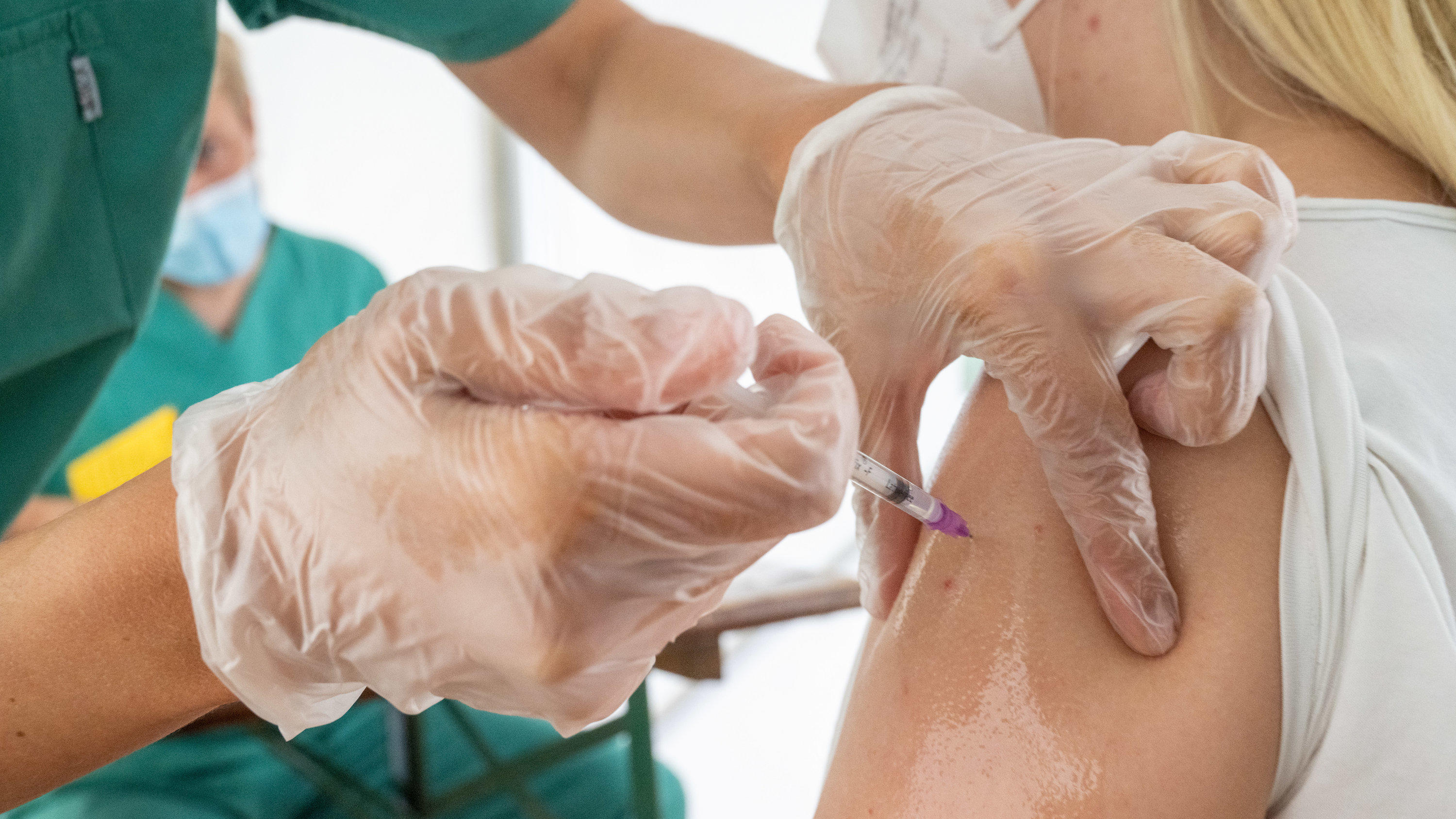 Eine junge Frau lässt sich von einer medizinischen Mitarbeiterin in einem Zelt der Gemeinde gegen das Coronavirus impfen. (zu dpa "Die Infektionen steigen rasch - wie viel Impfen geht noch?") Foto: