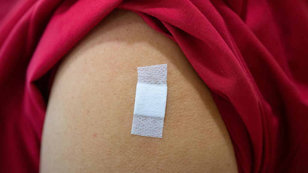 Eine Mitarbeiterin im Alten- und Pflegeheim Bürgerheim hat nach der Corona-Impfung mit dem Impfstoff von Biontech/Pfizer ein Pflaster auf dem Oberarm kleben. Das Pflaster zeigt: Hier wurde gerade jema