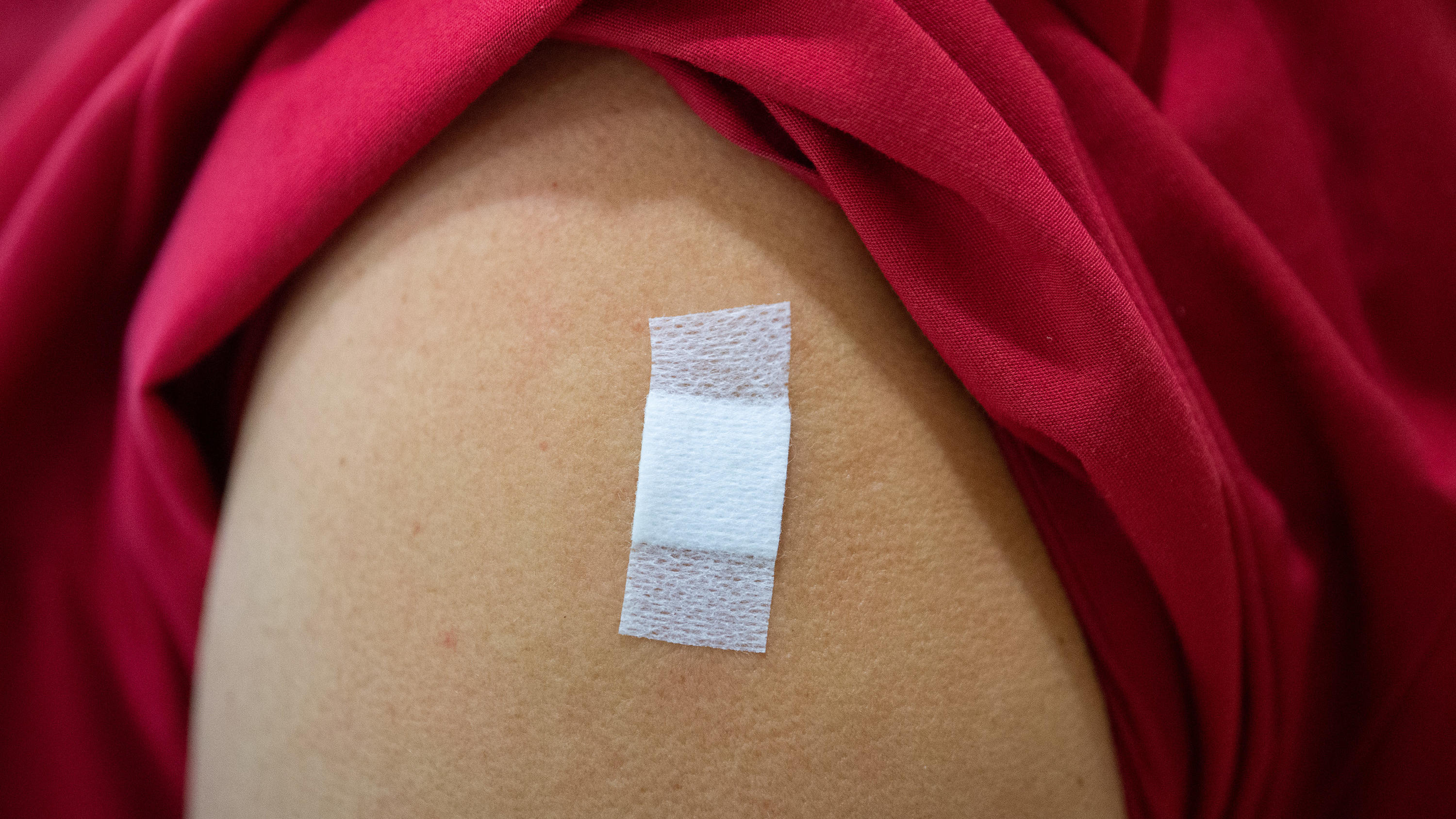 Eine Mitarbeiterin im Alten- und Pflegeheim Bürgerheim hat nach der Corona-Impfung mit dem Impfstoff von Biontech/Pfizer ein Pflaster auf dem Oberarm kleben. Das Pflaster zeigt: Hier wurde gerade jema