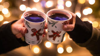 ARCHIV - 07.12.2020, Baden-Württemberg, Stuttgart: Zwei Frauen stoßen mit Glühwein in Bechern auf dem Weihnachtsmarkt an. Aus für Budenzauber und Glühwein: Baden-Württembergs Landeshauptstadt Stuttgart hat am Montagabend ihren Weihnachtsmarkt abgesagt. (zu dpa: "Stadt: Nun doch kein Weihnachtsmarkt in Stuttgart") Foto: Christoph Schmidt/dpa +++ dpa-Bildfunk +++