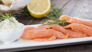 Portion of fresh Salmon with herbs on wooden background