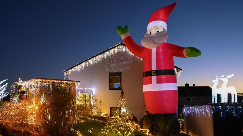 Zur blauen Stunde wird das Weihnachtshaus das erste Mal in dieser Saison in voller Beleuchtung gezeigt. Foto: Uwe Zucchi/dpa/Archivbild