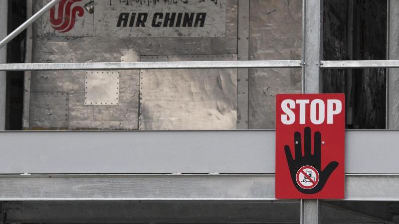 Ein rotes Warnschild mit der Aufschrift "Stop" hängt an einem Lager für leere Frachtcontainer im Cargo-Bereich des Flughafens Frankfurt. (Archivbild). Foto: Boris Roessler/dpa