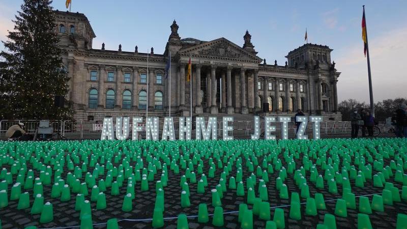 Ein Meer aus grünen Lichtern und der Schriftzug "Aufnahme Jetzt" vor dem Reichstag in Berlin. Foto: Jörg Carstensen/dpa