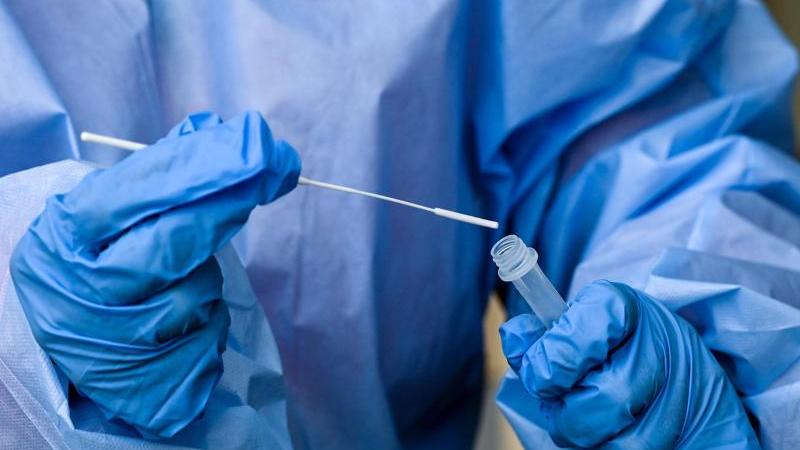 Eine Krankenschwester steckt ein Abstrichstäbchen in die Flüssigkeit eines Corona-Schnelltests. Foto: Jens Kalaene/dpa-Zentralbidl/dpa/Symbolbild