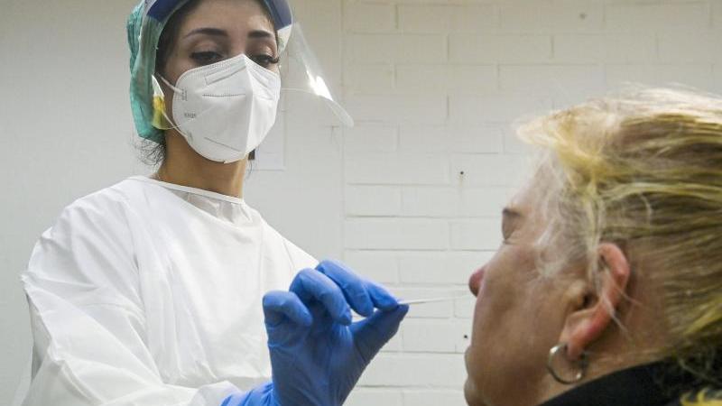 Eine medizinische Mitarbeiterin testet eine Frau auf das Coronavirus in einer Corona-Teststelle. Foto: Markku Ulander/Lehtikuva/dpa