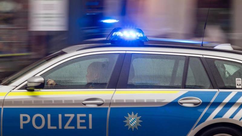 Ein Fahrzeug der bayerischen Polizei fährt mit Blaulicht durch die Innenstadt. Foto: Peter Kneffel/dpa/Symbolbild