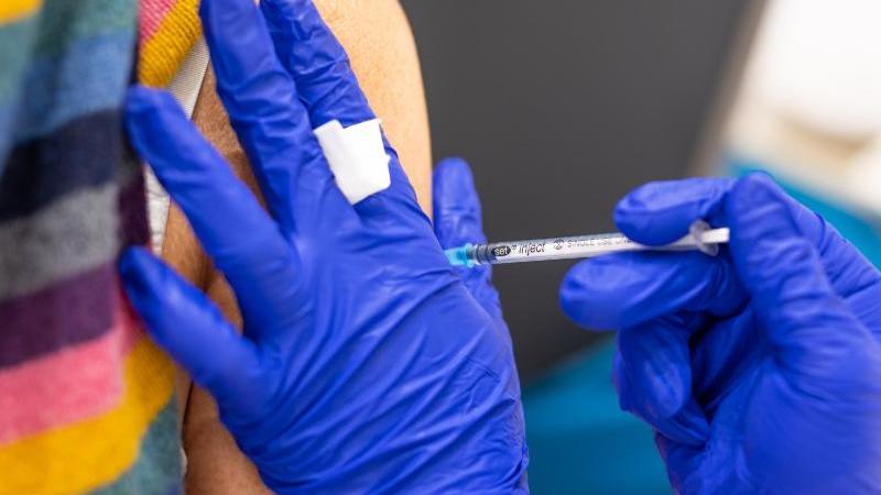 Die Mitarbeiterin eines Impfzentrums impft eine Frau gegen Corona. Foto: Moritz Frankenberg/dpa/Symbolbild