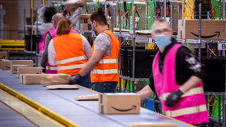 Mitarbeiter sortieren Paketsendungen des Online-Händlers Amazon im neuen Verteilzentrum. Das