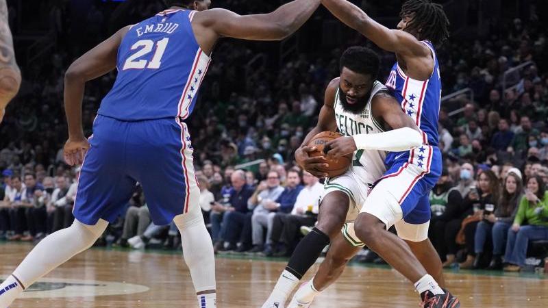 Boston Celtics-Guard Jaylen Brown (M) gegen Philadelphia 76ers-Guard Tyrese Maxey (r) und Center Joel Embiid. Foto: Charles Krupa/AP/dpa