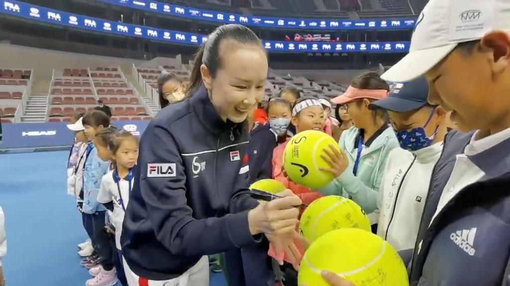 FILE PHOTO: Chinese tennis player Peng Shuai signs large-sized tennis balls at the opening ceremony of Fila Kids Junior Tennis Challenger Final in Beijing, China November 21, 2021, in this screen grab obtained from a social media video. TWITTER @QING