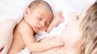 Newborn sleeping child in the hands of mother