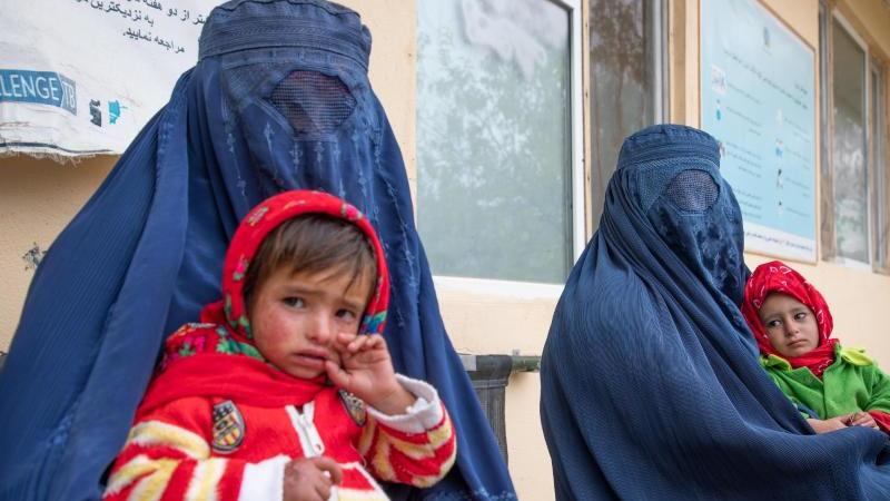 Zwei afghanische Frauen warten mit ihren Kindern vor einer Klinik für Ernährungsfragen. Foto: Julian Frank/WFP/dpa