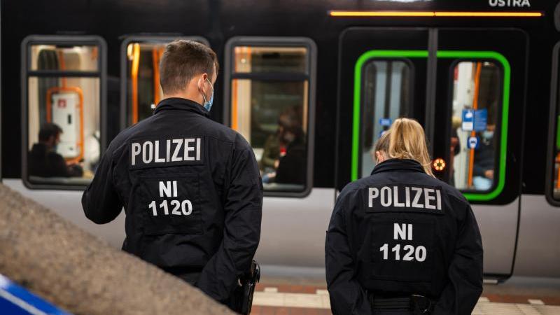 Beamte der Polizei stehen im Rahmen einer 3G-Nachweis Kontrolle in einer U-Bahn Station. Foto: Philipp Schulze/dpa/Bildarchiv