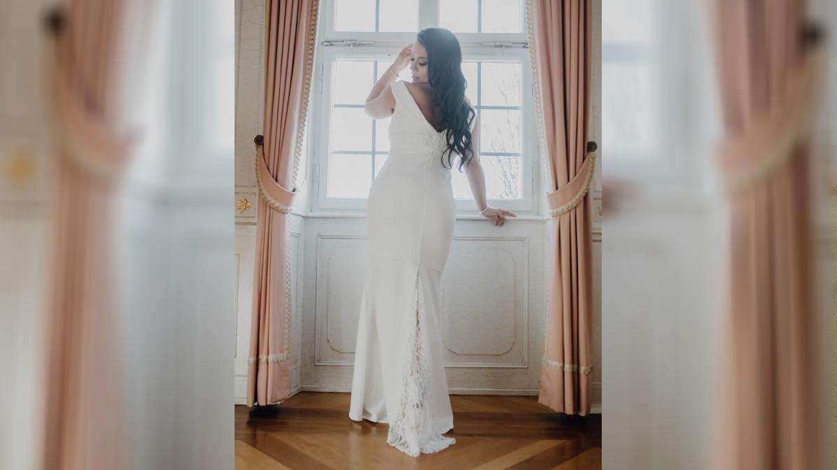 Im Brautkleid posiert das Model für die Kamera.