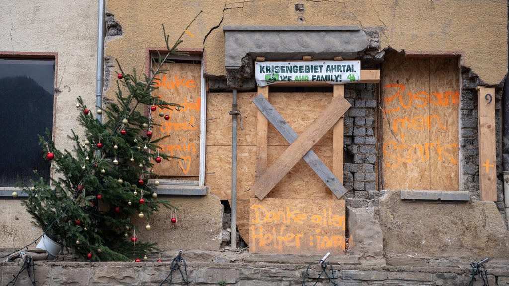 28.11.2021, Rheinland-Pfalz, Mayschoß: Festlich geschmückte Weihnachtsbäume stehen in Mayschoß vor vernagelten Fenstern an menschenleeren Straßen. Der Ort ist von der Flutkatastrophe im Juli besonders stark betroffen. Foto: Boris Roessler/dpa +++ dpa