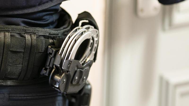 Handschellen sind an einem Gürtel eines Justizvollzugsbeamten befestigt. Foto: Frank Molter/dpa/Symbolbild