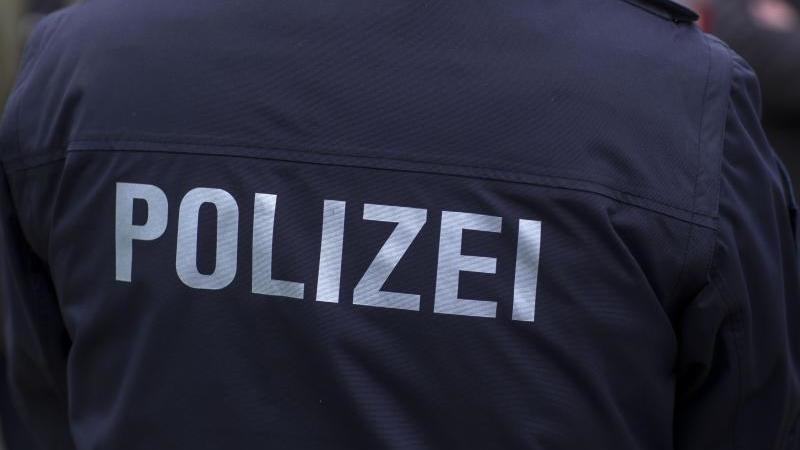 "Polizei" steht auf der Uniform eines Polizisten. Foto: Jens Büttner/zb/dpa/Symbolbild