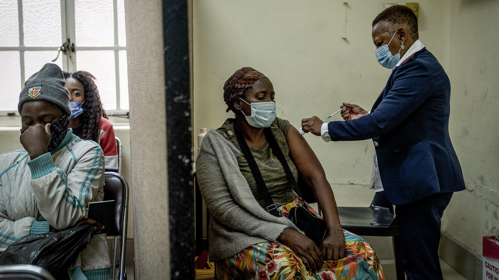 Eine Frau erhält in der Hillbrow Clinic einen Coronaimpfstoff. Südafrikanische Ärzte sagen, dass der rasche Anstieg der Corona-Fälle, die auf die neue Omikron-Variante zurückzuführen sind, meist zu milden Verläufen führe.