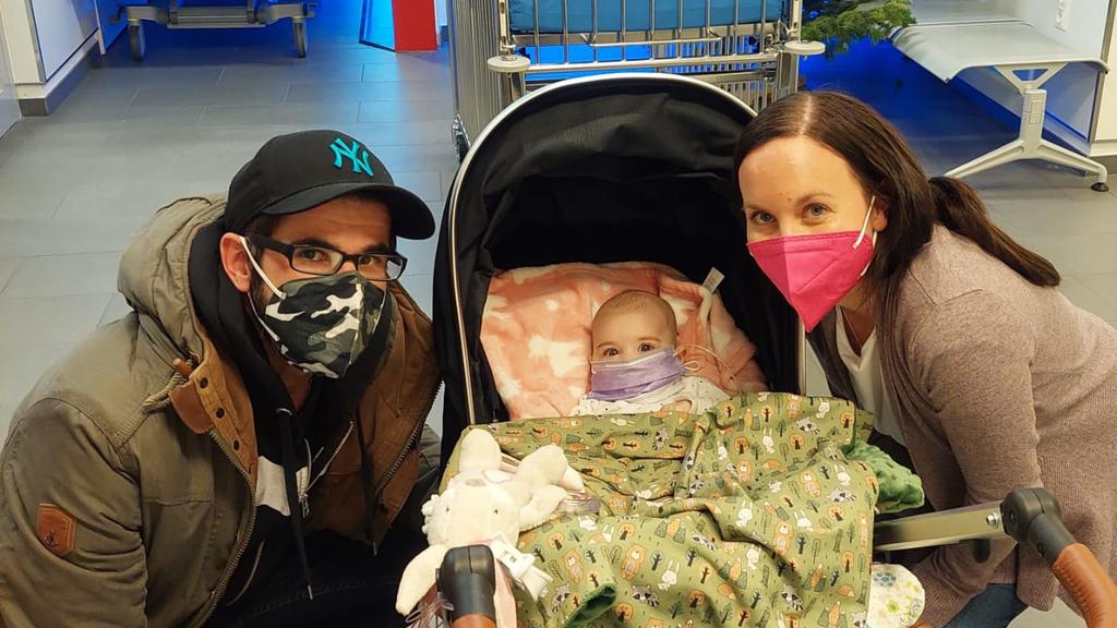 Die kleine Familie mit Masken im Krankenhaus.