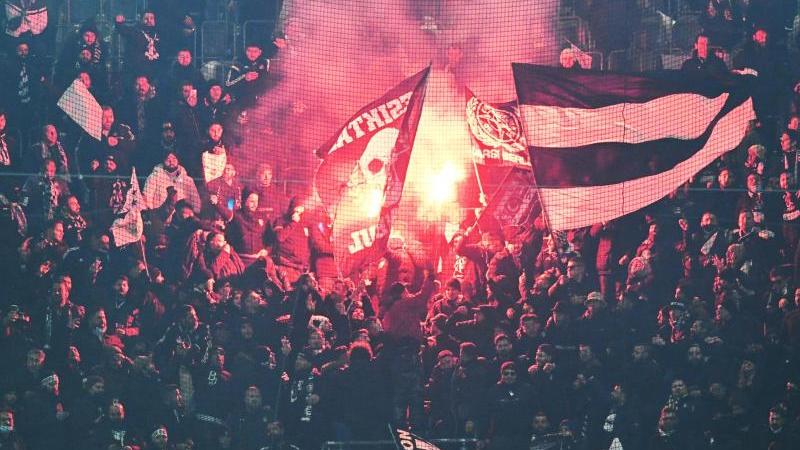 Fans von Besiktas stehen auf der Tribüne und zünden Pyrotechnik. Foto: Bernd Thissen/dpa