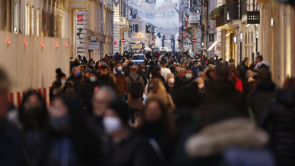 Einige Menschen gehen die zentrale Einkaufsstraße Via del Corso entlang.