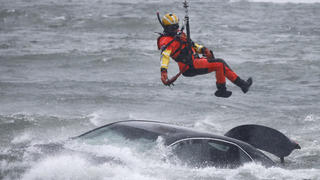 A U.S. Coast Guard diver is lowered from a hovering helicopter to pull a body from a submerged vehicle stuck in rushing rapids just yards from the brink of Niagara Falls, Wednesday, Dec. 8, 2021, in Niagara Falls, N.Y. (AP Photo/ Jeffrey T. Barnes)