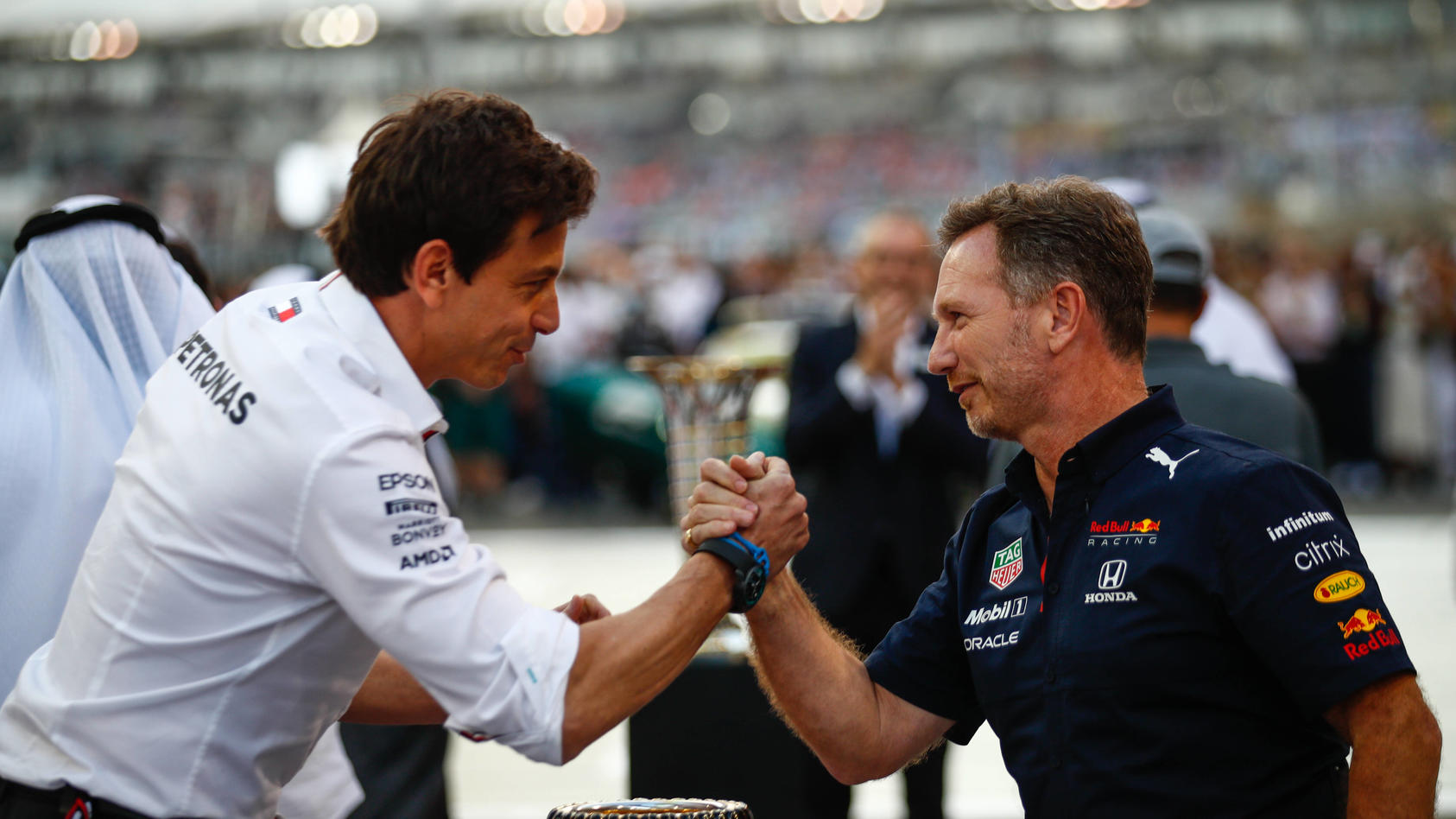  Formula 1 2021: Abu Dhabi GP YAS MARINA CIRCUIT, UNITED ARAB EMIRATES - DECEMBER 12: Toto Wolff, Team Principal and CEO, Mercedes AMG, and Christian Horner, Team Principal, Red Bull Racing, arm wrestle over the trophy on the grid during the Abu Dhab