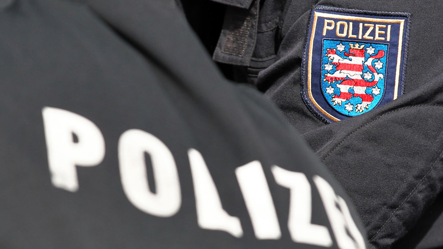 Der Schriftzug Polizei und das Logo von Thüringen stehen am Dienstag (10.04.2012) auf den Uniformen von zwei Polizeibeamten in Markkleeberg (Leipzig). Foto: Jan Woitas