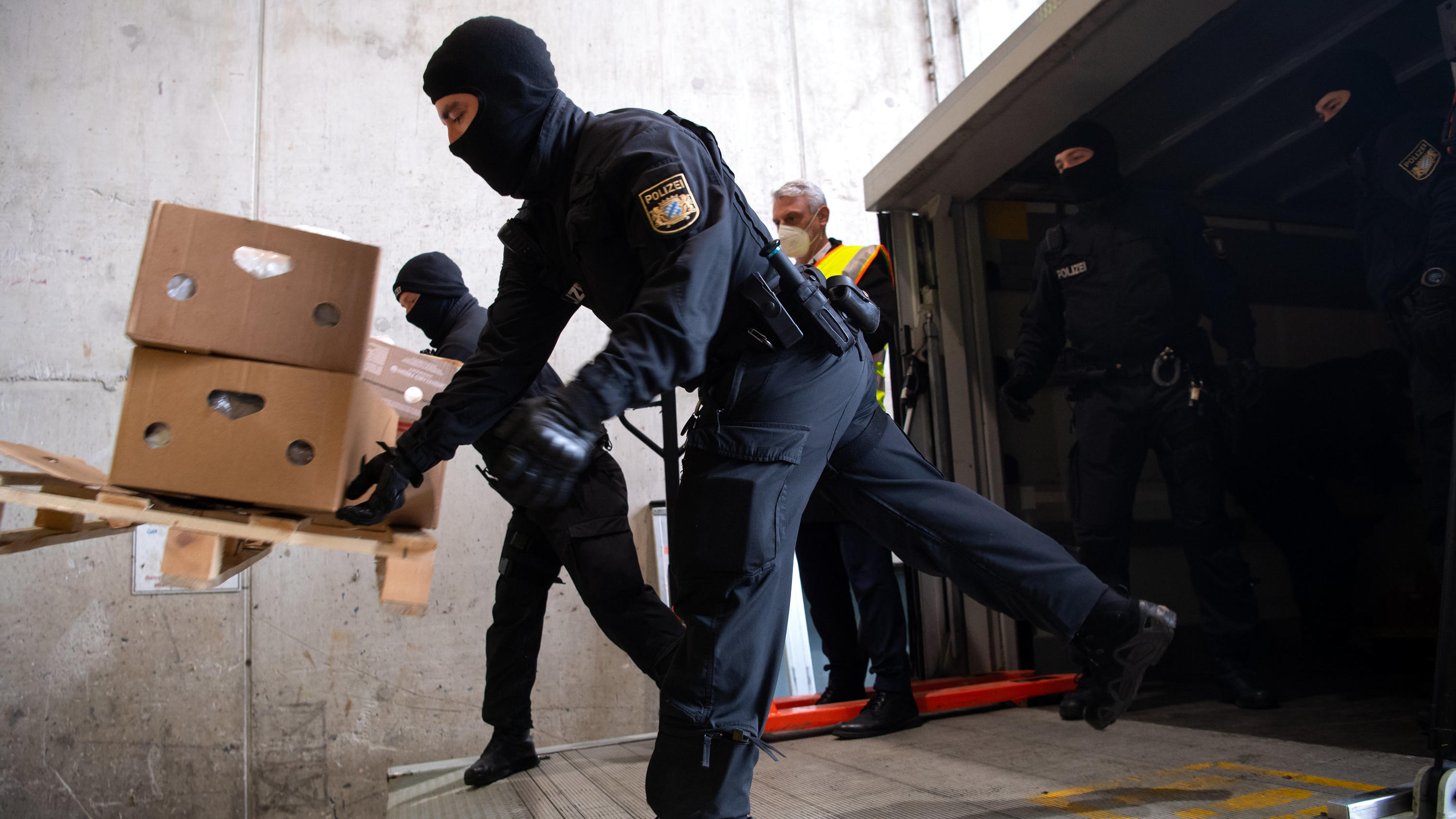 14.12.2021, Bayern, ---: Polizisten werfen Kisten mit Kokain in den Schacht von einer Müllverbrennungsanlage. Im Rahmen der Operation «Schneeschmelze» hat die bayerische Polizei unter strengsten Sicherheitsvorkehrungen das Kokain an einem geheimen Or